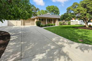 Ranch-style house featuring a gate, concrete driveway, a garage, a chimney, and stucco siding