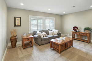 Living room with recessed lighting and light colored carpet