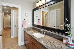Bathroom with vanity, light tile patterned floors, and recessed lighting