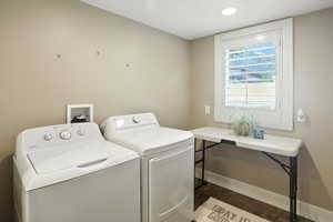 Laundry area with independent washer and dryer, dark wood-style flooring, and recessed lighting