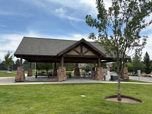 View of property's community with a patio and a lawn