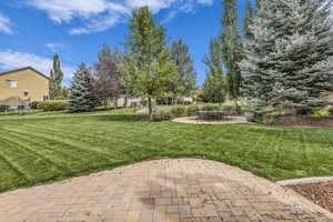 View of grassy yard featuring a patio area
