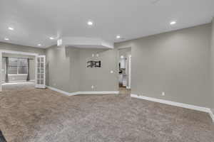 Unfurnished living room featuring light colored carpet and recessed lighting