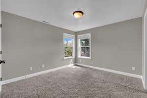 Carpeted spare room with baseboards