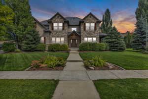 View of front of home featuring a front lawn and stone siding