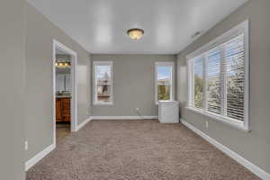 Unfurnished bedroom featuring light colored carpet and ensuite bathroom