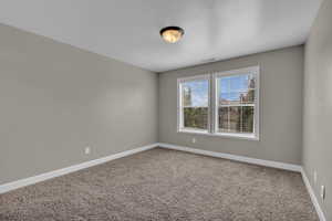 Carpeted empty room with baseboards