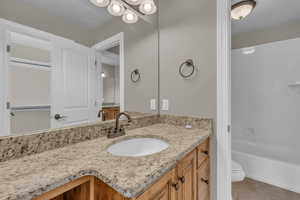Bathroom with vanity, light tile patterned flooring, shower / tub combination, and a chandelier