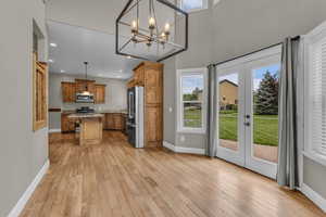 Kitchen with hanging light fixtures, a breakfast bar area, a kitchen island, brown cabinets, and healthy amount of natural light