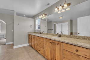 Bathroom with double vanity and light tile patterned floors