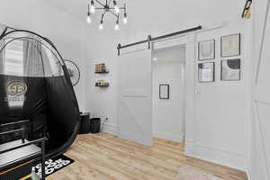 Office space featuring wood finished floors and a barn door