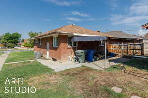Back of property with brick siding and a shingled roof