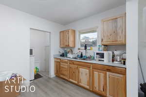 Kitchen with light countertops, light wood-type flooring, and light brown cabinetry