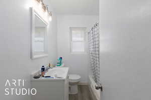 Full bath with vanity, light wood finished floors, and shower / bathtub combination with curtain
