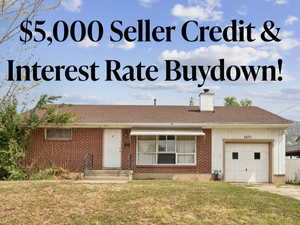 View of front facade featuring an attached garage, a front yard, a chimney, and brick siding