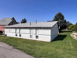 Back of property featuring a lawn