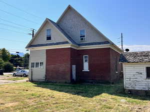 View of property exterior with a yard and brick siding