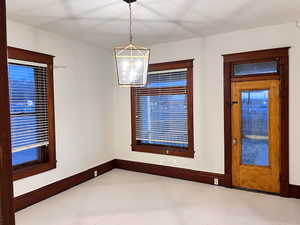 Unfurnished dining area with baseboards and light floors
