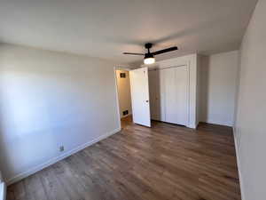 Unfurnished bedroom with dark wood-type flooring, ceiling fan, and a closet