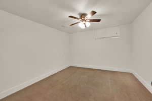 Empty room featuring light carpet and a ceiling fan