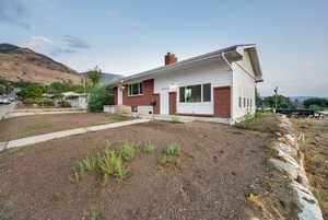 Single story home featuring a chimney, brick siding, and a mountain view