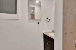Bathroom featuring electric panel and vanity