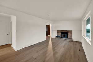 Unfurnished living room featuring light wood-type flooring and a wood stove