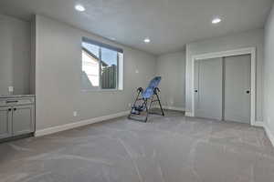 Exercise room featuring recessed lighting and light carpet