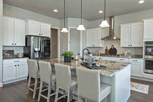 Kitchen with light stone counters, white cabinets, dark wood-style floors, and recessed lighting