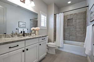 Bathroom with shower / bath combo, vanity, and light tile patterned floors