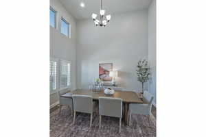 Dining room with a chandelier, a high ceiling, and dark wood finished floors