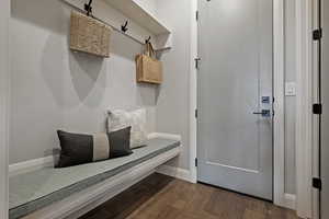 Mudroom featuring dark wood-style floors and baseboards