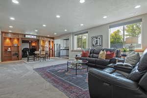 Living area featuring recessed lighting, light colored carpet, and a textured ceiling