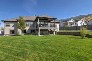Rear view of property with a patio, a yard, a shingled roof, and a deck