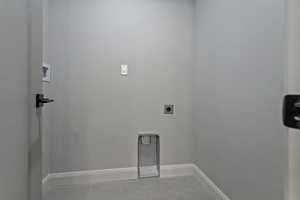 Laundry room featuring electric dryer hookup and light tile patterned floors