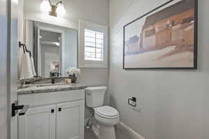 Half bathroom featuring vanity and toilet