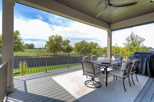 Wooden terrace featuring area for grilling, ceiling fan, outdoor dining area, and a fenced backyard
