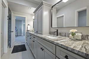 Bathroom with double vanity and light tile patterned floors
