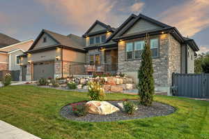 Craftsman-style home with stone siding and a garage