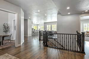 Corridor featuring an upstairs landing, dark wood finished floors, recessed lighting, healthy amount of natural light, and a textured ceiling
