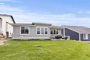 Rear view of property with a patio area and a yard
