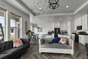 Living room with a chandelier, recessed lighting, and a tray ceiling
