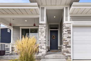 Doorway to property featuring stone siding and a garage