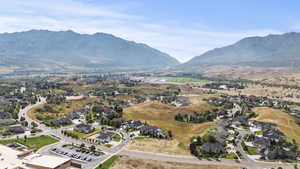 Aerial view of property and surrounding area with nearby suburban area and mountains