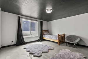 Bedroom with baseboards and a textured ceiling