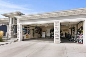 Garage featuring concrete driveway and freestanding refrigerator