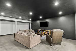Cinema room with finished concrete floors and recessed lighting