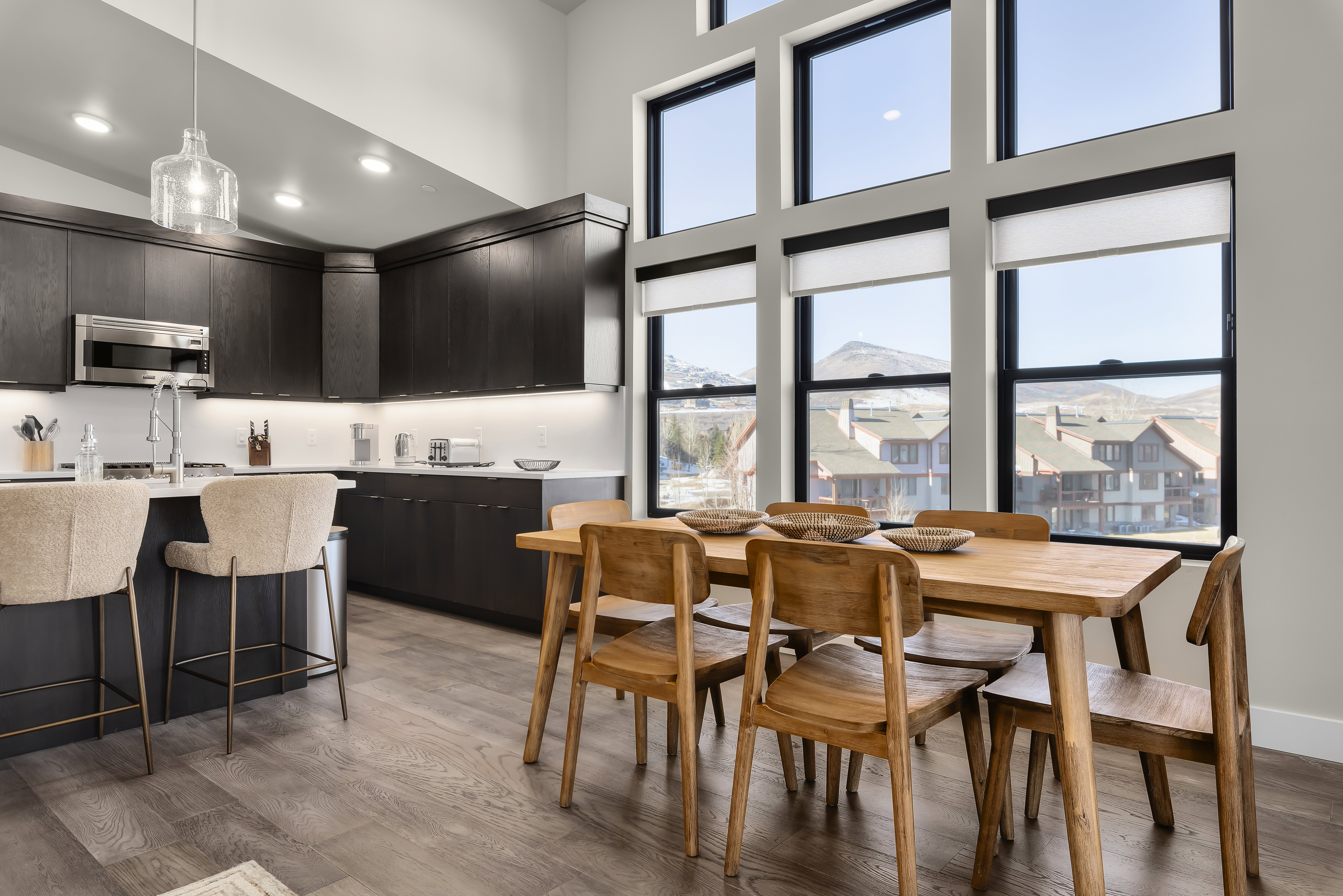 Dining room with plenty of natural light, light wood-style flooring, a towering ceiling, and recessed lighting