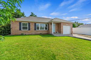Single story home with an attached garage, brick siding, a shingled roof, and concrete driveway