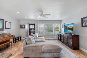 Living room featuring recessed lighting, ceiling fan, and light wood-style flooring